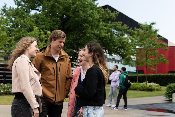 Een groepje studenten staat te kletsen.