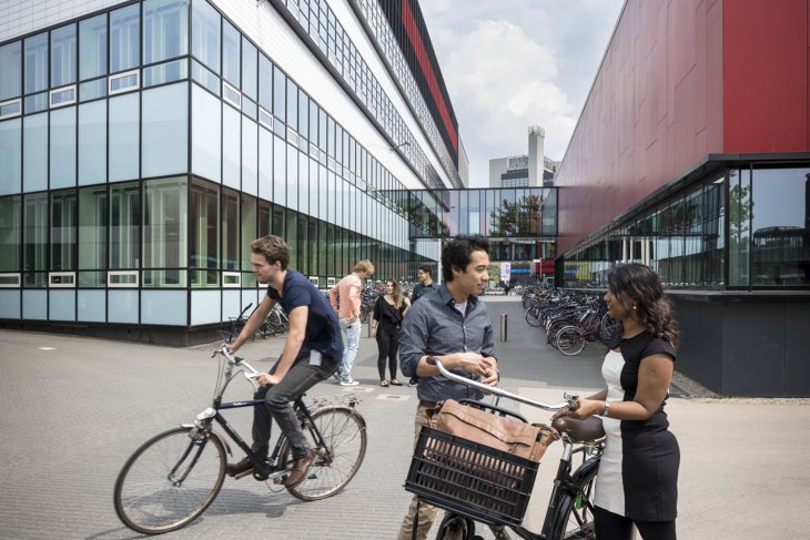Students talking and biking on the University of Twente campus